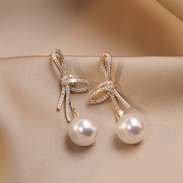 Gold Bow Pearl Earrings with a Shiny Finish